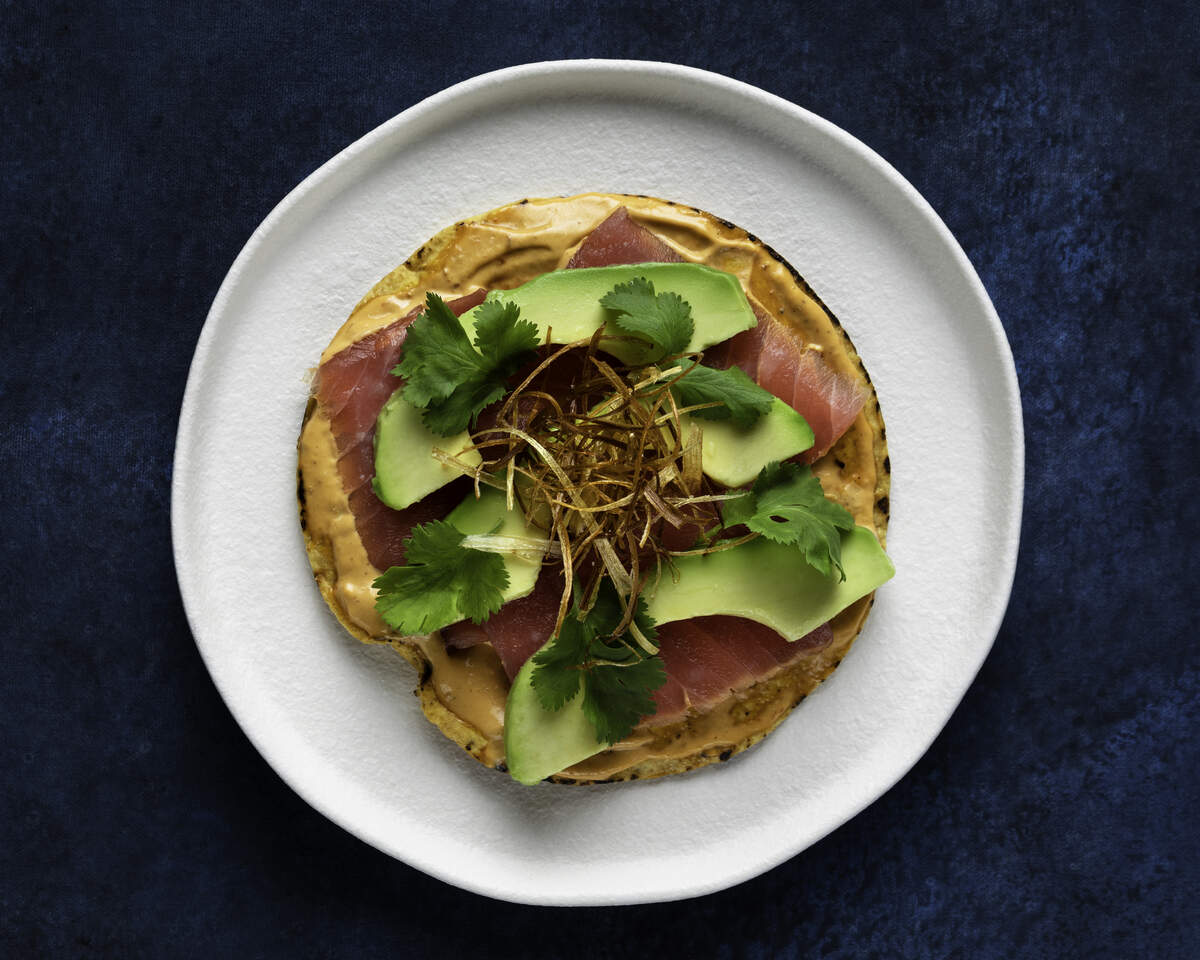 Tuna Tostadas at Belly Fish feature a crunchy corn wafer was weighed down with a bold chipotle aioli, soy-lime marinated yellowfin tuna, avocado, cilantro and crispy leeks.